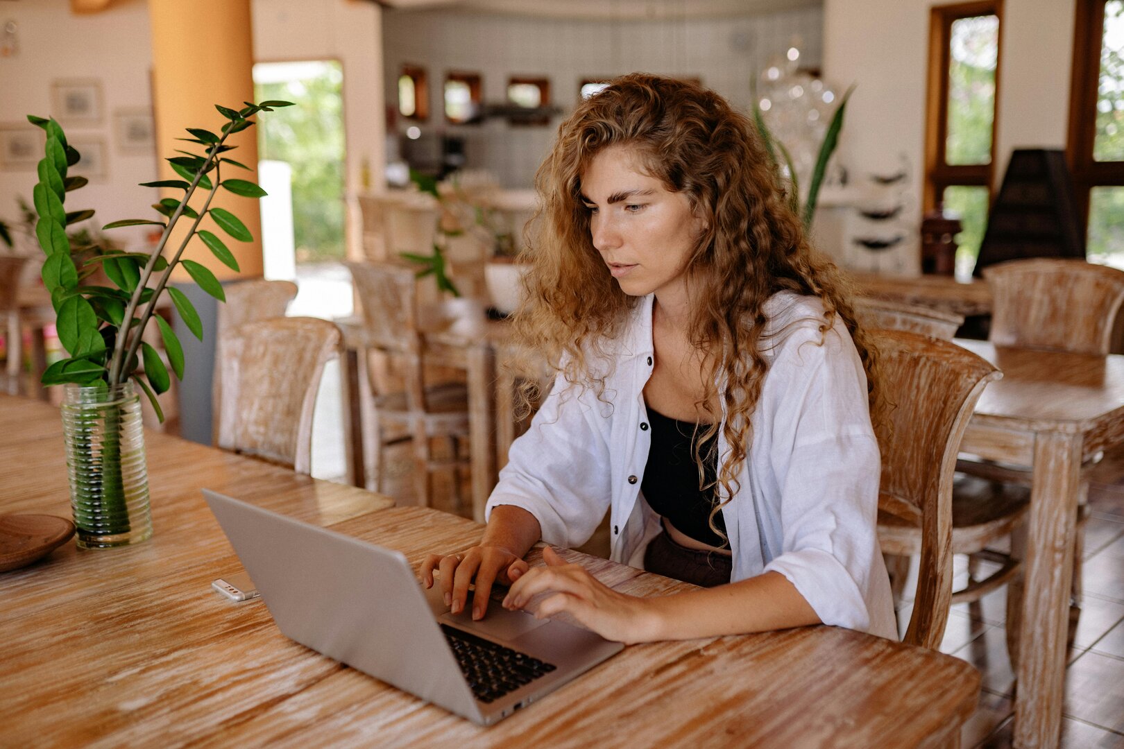mujer trabajando en un ordenador portátil en un espacio luminoso con decoración moderna
