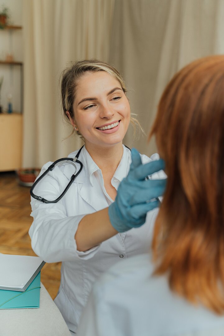 médica sonriente atendiendo a una paciente en una consulta profesional