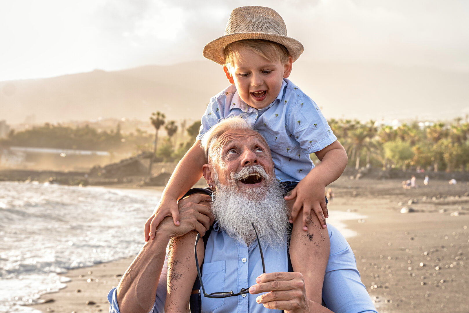 Abuelo cargando a su nieto en la playa